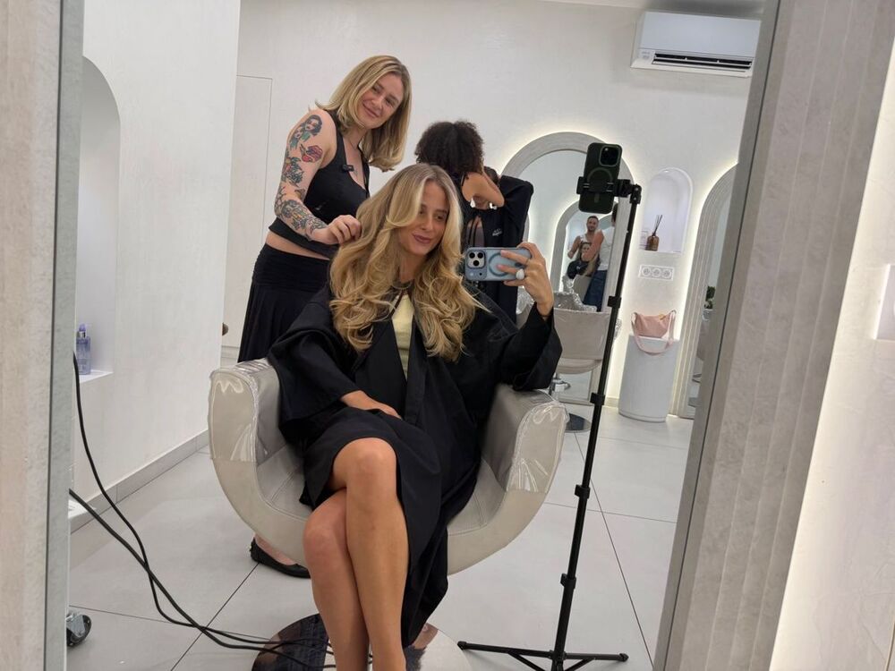 A salon chair set up with a tripod, filming the work